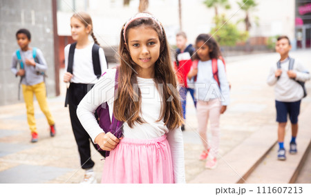 Smiling tween schoolgirl going to school on autumn day 111607213