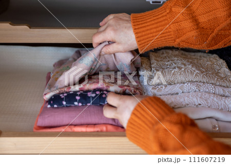 衣服の整理をしているシニア女性の手元 衣服の整理をしているシニア女性の手元 111607219