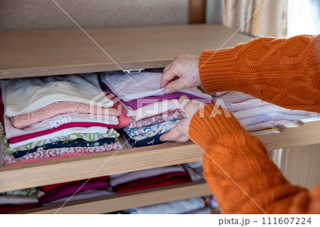 衣服の整理をしているシニア女性の手元 衣服の整理をしているシニア女性の手元 111607224