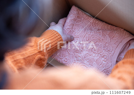 衣服の整理をしているシニア女性の手元 111607249