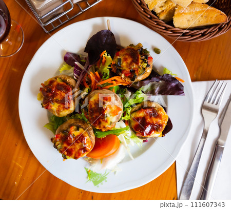 Baked mushrooms stuffed with vegetables, ham and mozzarella Baked mushrooms stuffed with vegetables, ham and mozzarella 111607343