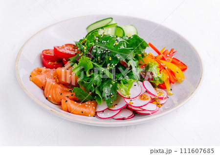 Smoked or salted salmon salad with cucumbers, arugula, peppers and radishes 111607685