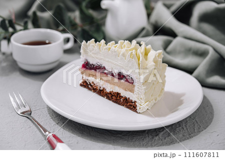 Layered Mousse Cake on white plate and cup of tea Layered Mousse Cake on white plate and cup of tea 111607811