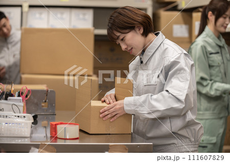 梱包作業をする作業服姿の女性 111607829