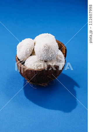 Coconuts with candies on blue background 111607998