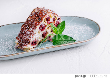 Triangle cherry cake with cream and chocolate sprinkles 111608076