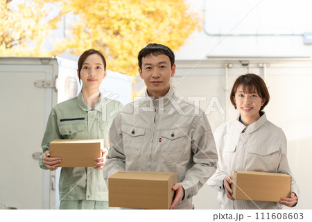 荷物を持つ作業服姿の男女 111608603