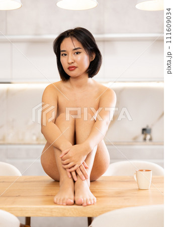 Young naked asian girl sitting on table Young naked asian girl sitting on table 111609034