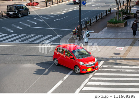 交差点を左折する軽自動車 111609298