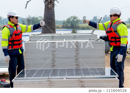Two Asian technician worker stand beside solar cell panel and show thumbs up to each other in concept of green energy system and success of work. 111609526