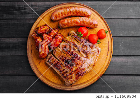 pork ribs with chicken and sausages on wooden board 111609804