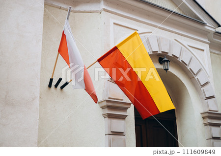 Warsaw flag and Flag of Poland on facade of a building waving in the wind. Celebrating Polish National Flag Day. 111609849