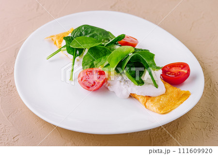 Omelet with tomatoes and herbs on a plate Omelet with tomatoes and herbs on a plate 111609920