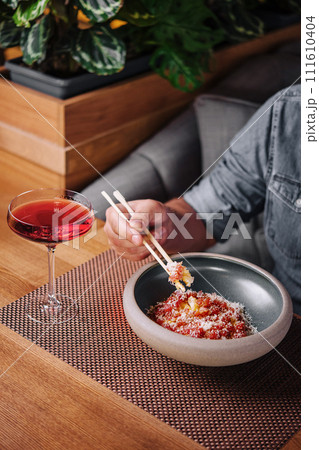 Man Eating Salmon Tartare with Parmesan Cheese 111610404