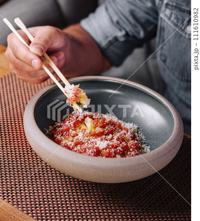 Man Eating Salmon Tartare with Parmesan Cheese 111610982