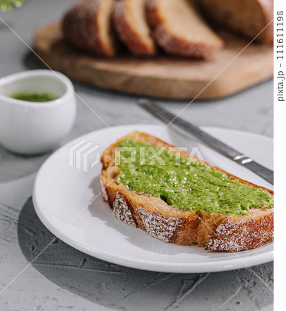 bread with homemade pesto sauce spread with a knife bread with homemade pesto sauce spread with a knife 111611198