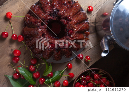 Delicious chocolate cake with sweet cherry and vintage kettle on dark wooden background.. 111611270