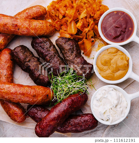 Beer set of grilled sausages with stewed cabbage and sauces Beer set of grilled sausages with stewed cabbage and sauces 111612191