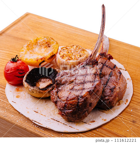 Grilled lamb chops on wooden board with herbs and spices Grilled lamb chops on wooden board with herbs and spices 111612221