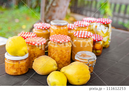 Table displaying jars of jam, lemons, and other natural food ingredients Table displaying jars of jam, lemons, and other natural food ingredients 111612253