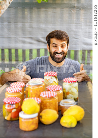 Happy man at table with natural foods and lemons, giving thumbs up 111612265