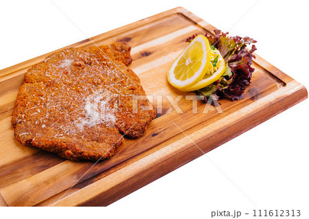 Schnitzel with salad on wooden tray 111612313