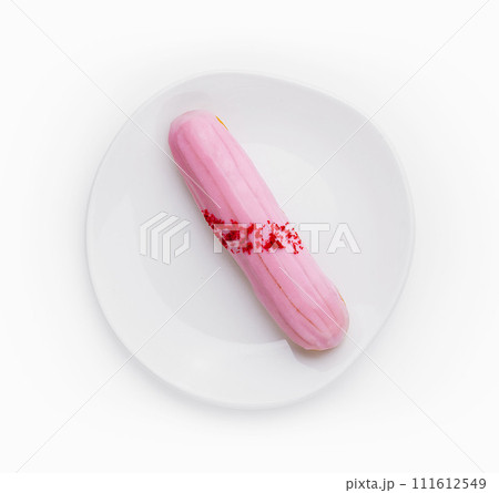 Eclair dessert with pink icing on plate 111612549