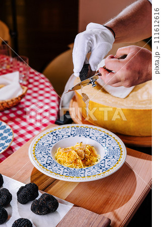 Chef Grating Truffle Shavings on Pasta with Parmesan 111612616