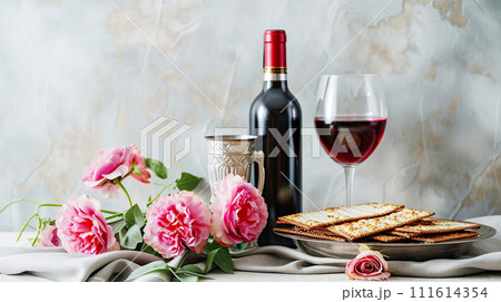 Elegant Passover celebration setting with wine, matzo and spring flowers on a light table. Religious Jewish Passover concept Elegant Passover celebration setting with wine, matzo and spring flowers on a light table. Religious Jewish Passover concept 111614354
