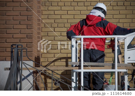 construction worker mason in cherry picker restoring brick wall construction worker mason in cherry picker restoring brick wall 111614680