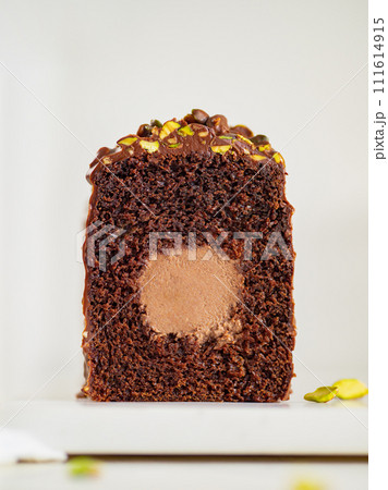 Travel Cake or Tube Cake or Voyage Cake filled center tube ganache and topped chocolate icing and pistachio. Chocolate loaf cake with chocolate cream-cheese filled center. Copy space. Vertical Travel Cake or Tube Cake or Voyage Cake filled center tube ganache and topped chocolate icing and pistachio. Chocolate loaf cake with chocolate cream-cheese filled center. Copy space. Vertical 111614915