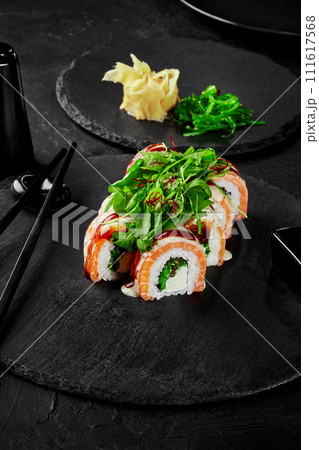 Sushi rolls with cream cheese, hiyashi wakame and salmon on slate board 111617568