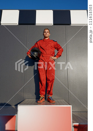 Speed go-cart driver winner standing on pedestal achieving first place 111618303