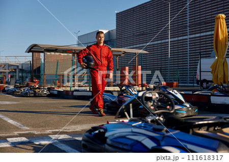 Go-kart driver walking to car before race at starting line Go-kart driver walking to car before race at starting line 111618317