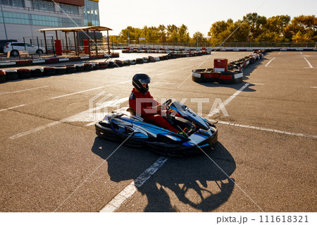 Karting pilot ready to start championship in outdoor go-karting circuit 111618321