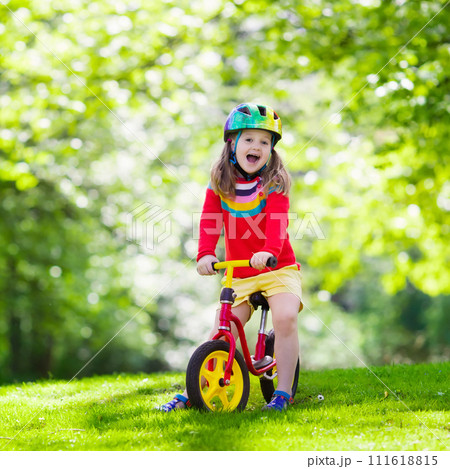 Kids ride balance bike in park 111618815