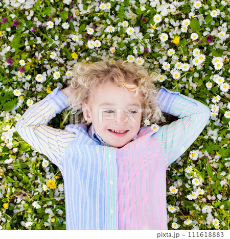 Child on green grass lawn with summer flowers 111618883