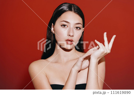 Fashionable Woman: A Pretty Caucasian Model with Stylish Black Hair, Posing Indoors with a White Background and Talking on the Phone 111619890