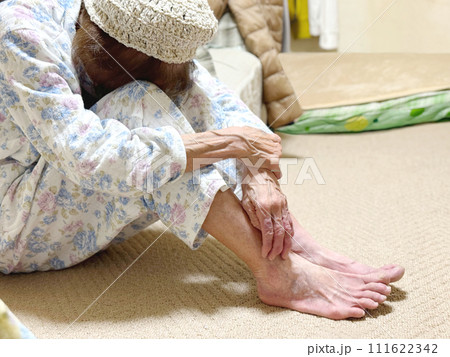 寝巻で座ってうなだれる高齢女性 111622342