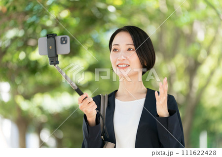 スマホで自撮りをするスーツの女性 111622428