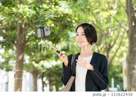 スマホで自撮りをするスーツの女性 111622430