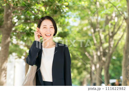 新緑の中で微笑むスーツを着た30代女性 新緑の中で微笑むスーツを着た30代女性 111622982