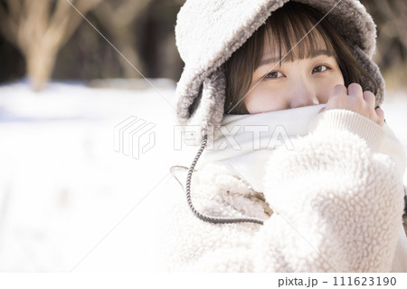 マフラーで顔を隠す若い女性 111623190