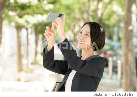 スマホで写真を撮るビジネスウーマン 111623268