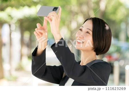スマホで写真を撮るビジネスウーマン 111623269
