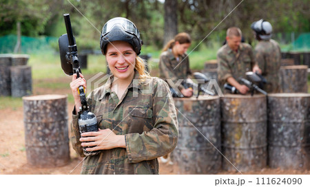 Portrait of girl in camouflage on paintball field Portrait of girl in camouflage on paintball field 111624090