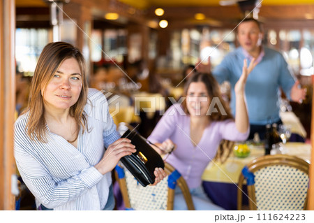Woman leaving restaurant after stealing handbag Woman leaving restaurant after stealing handbag 111624223