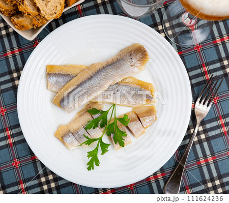 Pieces of pickled herring served on platter 111624236