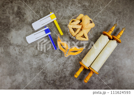 Symbol celebration Jewish Purim holiday with hamantaschen hamans ears cookies, carnival mask, noisemaker Symbol celebration Jewish Purim holiday with hamantaschen hamans ears cookies, carnival mask, noisemaker 111624593