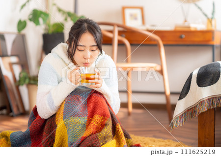 部屋でお茶を飲む大学生の女性 111625219